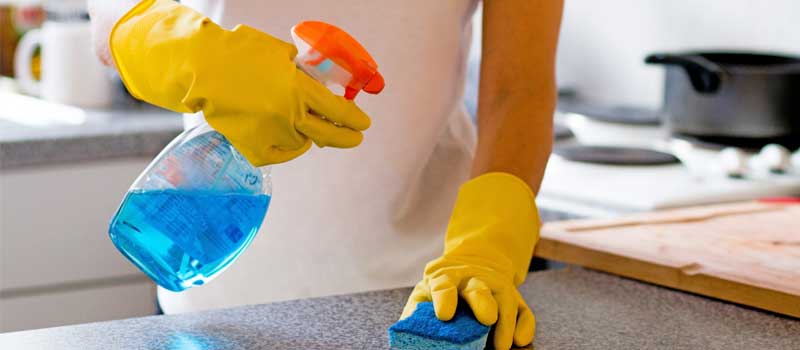 Maids hands with yellow gloves while cleaning